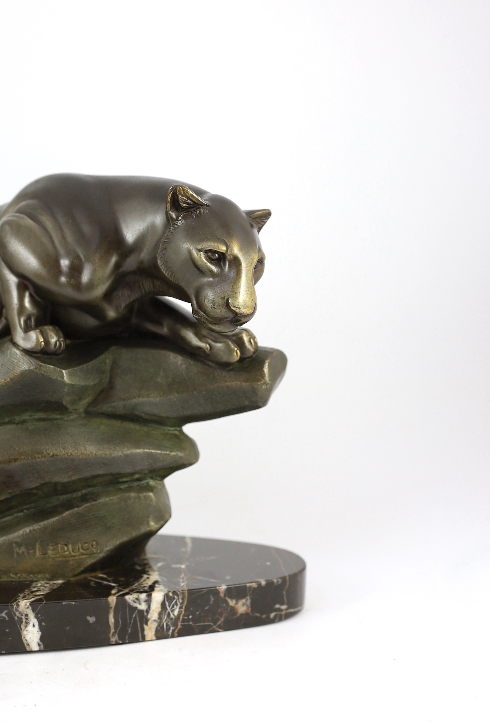 M. Leducq. NB. A patinated spelter model of a panther crouched upon a rock, width 60cm height 29cm